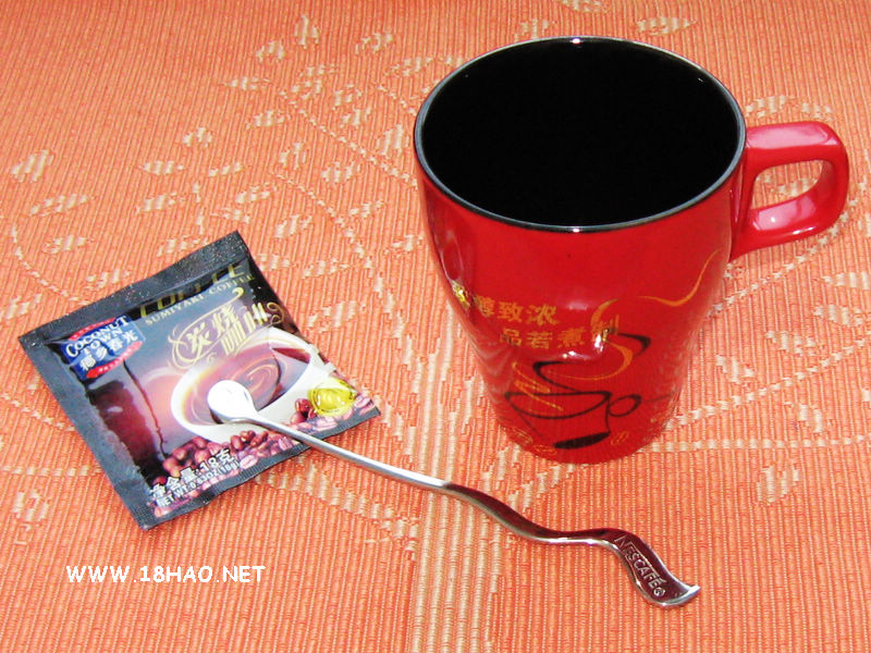 用雀巢搅拌棒搅拌盛在麦斯威尔咖啡杯中的海南春光炭烧咖啡